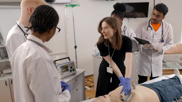 Medical students learning defibrillator use during resuscitation training class