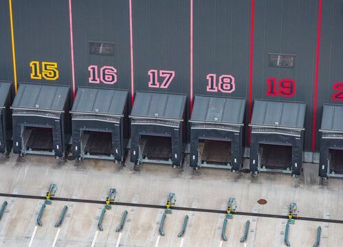 Aerial view of numbered loading docks and empty truck bays at a modern warehouse and logistics distribution facility in France.
