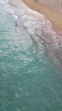 Top Down Aerial View of Turquoise Sea Waves Splashing Sand Beach