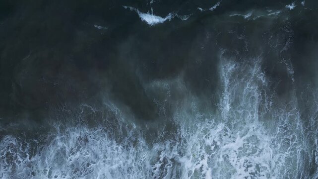 Top Down Aerial View of Dark Sea Water with White Foamy Waves