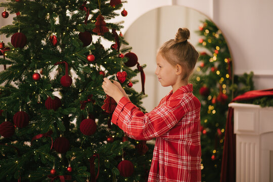 Cute 7-years old girl decorating Christmas tree