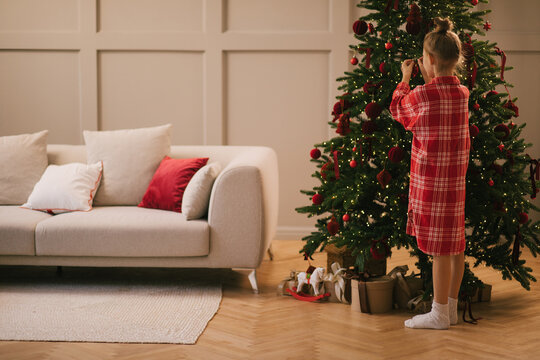 Cute 7-years old girl decorating Christmas tree