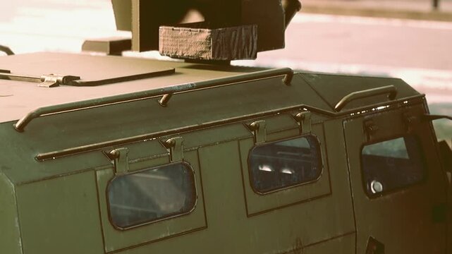 The sturdy military vehicle is parked in a green open area, illuminated by warm sunlight. Its robust features highlight resilience and adaptability in various terrains.