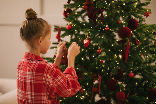 Cute 7-years old girl decorating Christmas tree