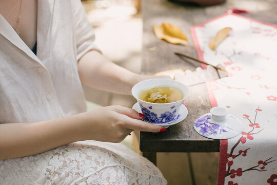 Beautiful young woman drinking jasmin tea sitting in a traditional chinese tea house.