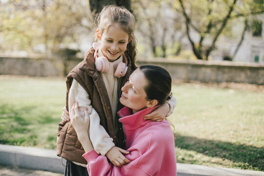 Happy mother and daughter relaxing in a park on sunny day.