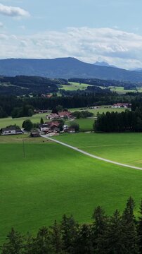 Peace and beauty of nature, summer day in the mountains. Tourism, ecology concept, travel and nature. Bird's eye view of green meadow, forest and majestic mountain ranges. Breathtaking landscape