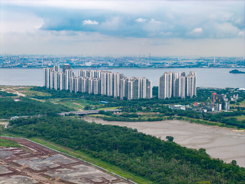 Aerial view of Forest City residential towers surrounded by lush greenery and coastal waters in Iskandar Puteri, Johor, Malaysia.
