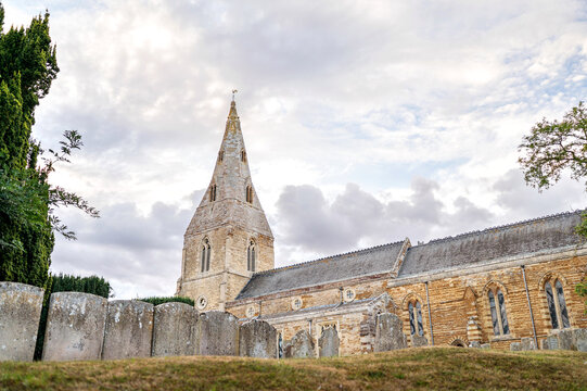 Historic English parish church surrounded by old stone gravestones
