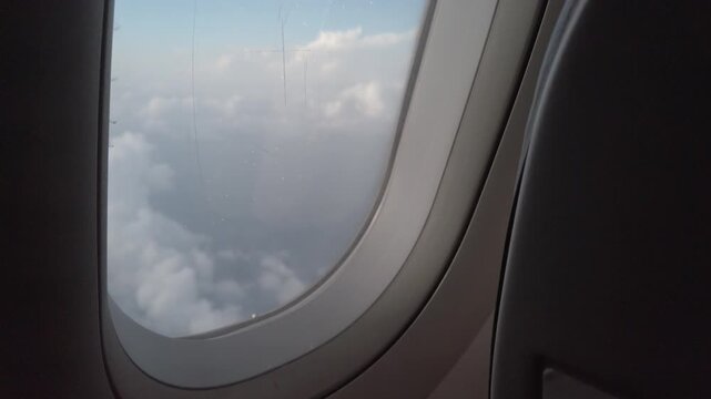 plane window view flying over sea of clouds on cloudy day for travel holiday vacation background