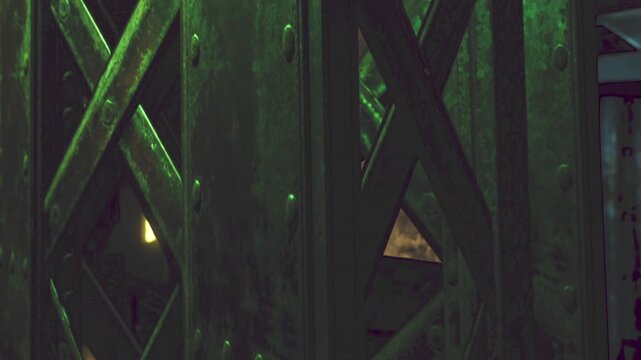 An atmospheric scene captures rusting structures illuminated by dim green lights. The setting reveals a sense of decay and mystery, inviting imagination amid shadows.
