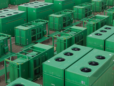 Aerial view of industrial battery storage units arranged in rows on a gravel site in the United Kingdom.
