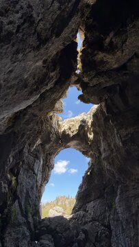 Adventure exploration of deep karst caves and rocky arches in remote mountains
