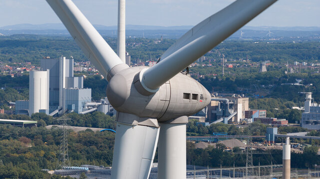 Aerial view of the Halde Hoppenbruch wind turbine with industrial facilities and green landscape in the background in Herten, North Rhine-Westphalia, Germany.