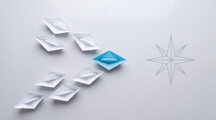 Fototapeta premium Top view of a blue paper boat leading a fleet of white origami boats towards a compass star symbol on a grey background, representing leadership, business vision, and strategic direction.