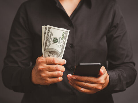 Woman holding cash and smartphone for finance concept  