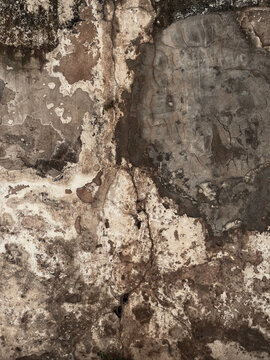 Weathered cracked stone wall with aged plaster and natural texture
