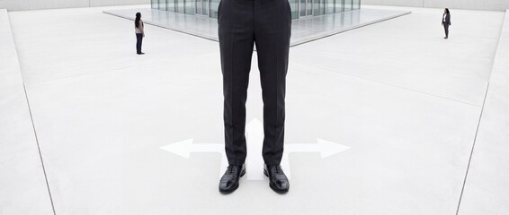 Fototapeta premium Businessman standing at a crossroad with white arrows pointing in three different directions, representing professional decision making, career path choices, and strategic planning in corporate life.