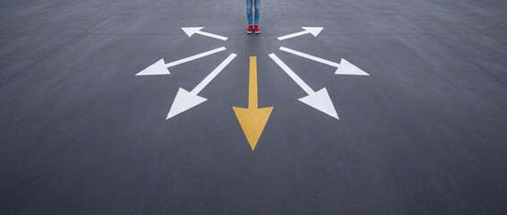 Fototapeta premium Person in Red Sneakers Standing at a Crossroads on Asphalt Surface with Multiple White and One Yellow Directional Arrows Representing Life Choices, Career Decisions, Strategy and New Opportunities