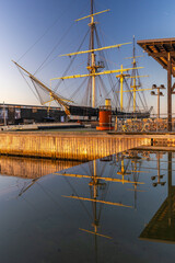 Historic steam frigate Jylland reflecting in calm harbor water at sunset © LeonHansenPhoto