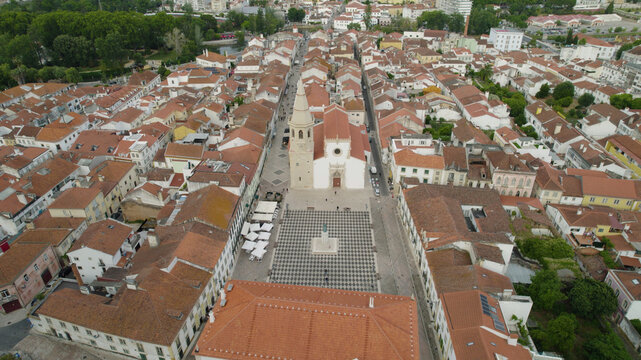 Aerial view of the historic Praca da Republica and the Church of Saint John the Baptist surrounded by traditional tiled rooftops in the city center of Tomar, Santarem District, Portugal.