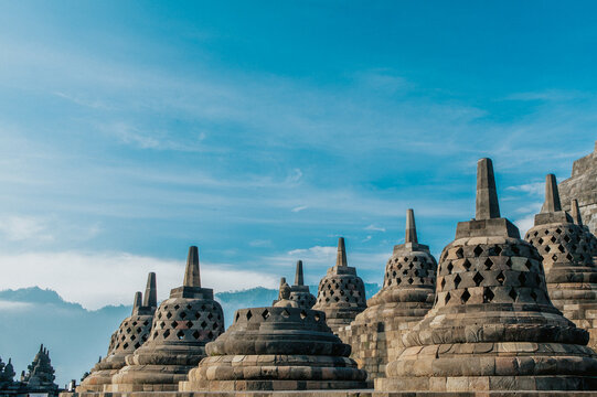 Borobudur temple stupas stand majestically under a clear blue sky in Java, Indonesia.