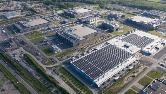 Aerial view of the Google data center in Saint-Ghislain, featuring large industrial buildings with solar panels and cooling units in Saint-Ghislain, Region wallonne, Belgium.