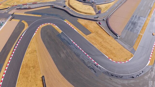Orange Race Car Speeds Through a Sharp Turn on a Professional Circuit