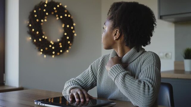 Lifting screen, child in gray turtleneck preparing 2-in-1 laptop at kitchen table for class