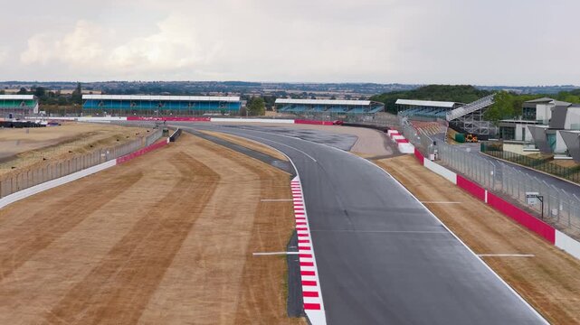 Race Car Speeds Around the Silverstone Circuit Track Curve