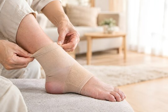 Caregiver adjusting a compression sock on a swollen ankle