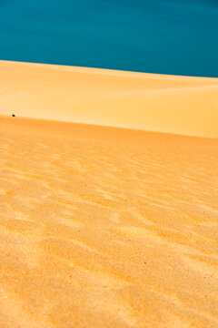 Orange sand dune with blue sky above