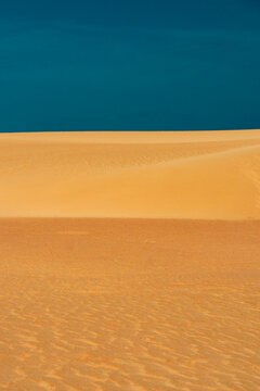 Golden dune slope beneath a deep blue sky