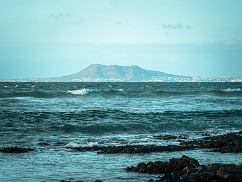 Blue ocean waves near a distant coastline
