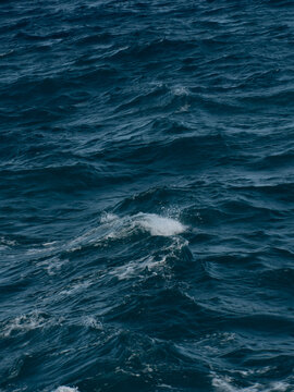Textured blue sea with small breaking waves