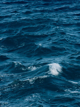 Deep blue ocean waves with white foam