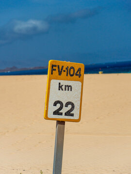 Fuerteventura road marker against dunes and blue sky
