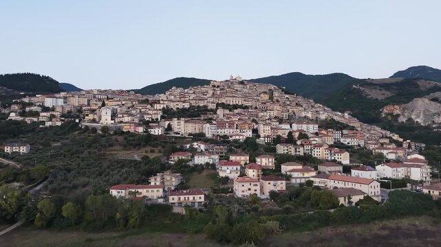 Aerial view of the hilltop village of Padula at dusk above the Vallo di Diano valley, Salerno, Campania, southern Italy