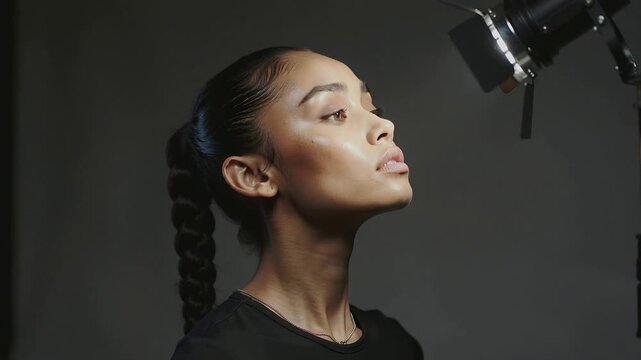 Responding to spotlight shift studio model lifting chin lengthening neck wearing black top necklace