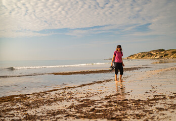 Active senior woman walking barefoot on Cadiz beach at sunset © Paolo Corazza
