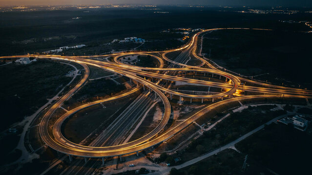 Aerial view of a highway interchange with light trails at night interchange junction transportation infrastructure illumination expressway landscape perspective cityscape engineering