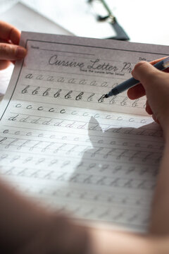 Physical over Digital concept. Woman training calligraphy at desk. Handwriting improves concentration and conceptual understanding better than digital notes. Perfect tool for mental clarity