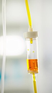 A medical infusion system on a metal tripod delivers healthcare treatment in a hospital room, featuring a transparent tube and drip chamber for professional administration of medicine