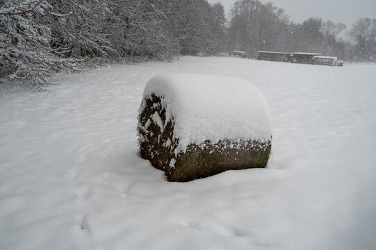A hay bale in the countryside with lots of snow.