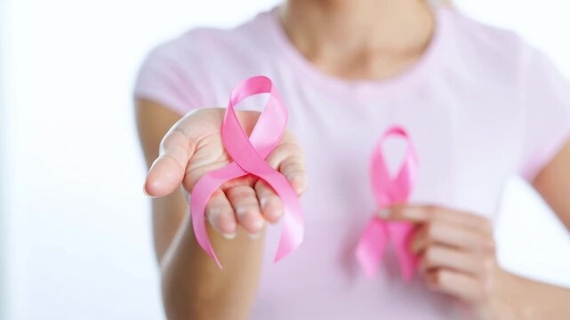 Woman holding pink ribbon for breast cancer awareness supporting early detection screening prevention research patient care