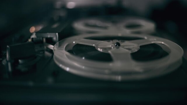 Reel of a vintage tape recorder turning at a professional player. Old analog sound and retro audio