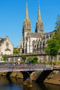 woman tourist standing on footbridge looking at quimper cathedral quimper france travel concept