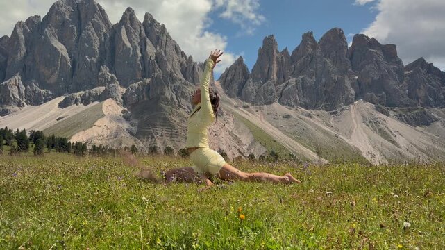Woman Stretching in Pigeon Pose Yoga in an Alpine Meadow in the Dolomites
