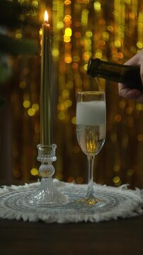 Vertical video. New year celebration, festive party. Pouring champagne or sparkling wine into a glass