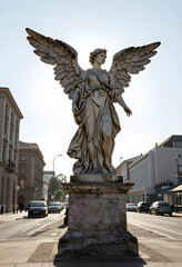 Fototapeta premium Spirituality and hope concept, stone angel statue with wings spread standing on a pedestal in a city street with backlight and urban architecture